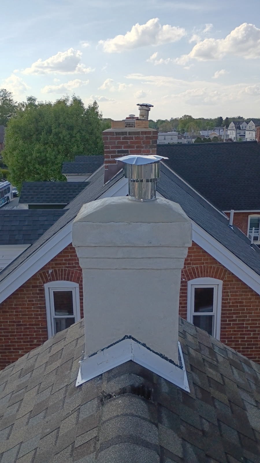 Completed stainless steel chimney cap installation on a brick rowhome chimney