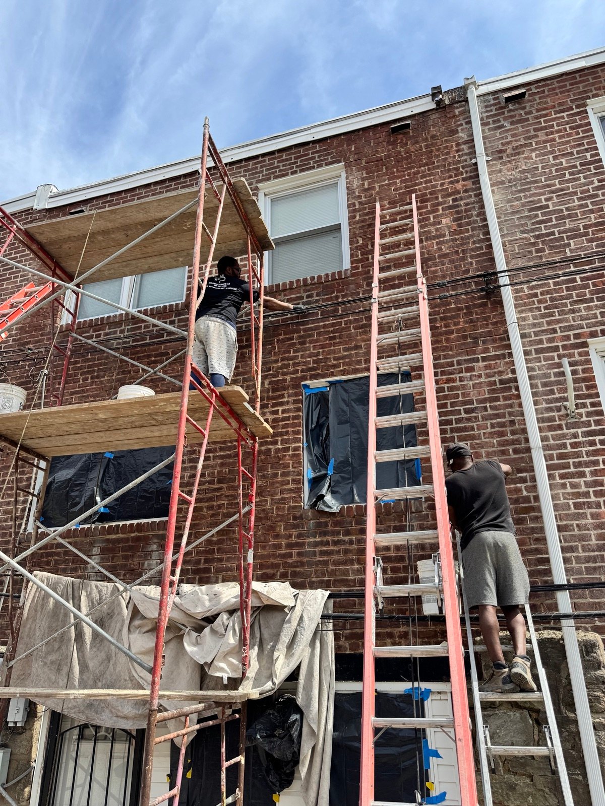 Technicians performing masonry and tuckpointing repair on scaffolding
